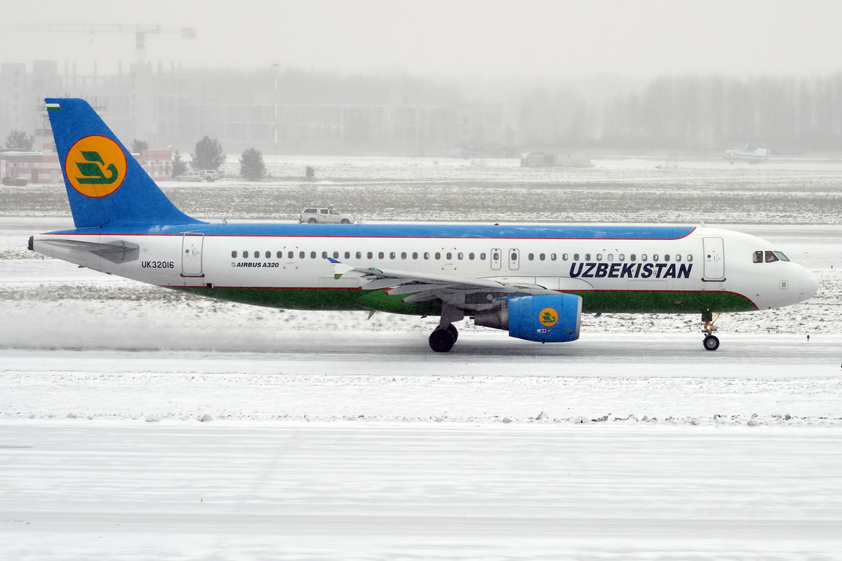 Uzbekistan Airways Airbus A320 qor bosgan rulyojka yoʻlagida, kilda aviakompaniya emblemasi